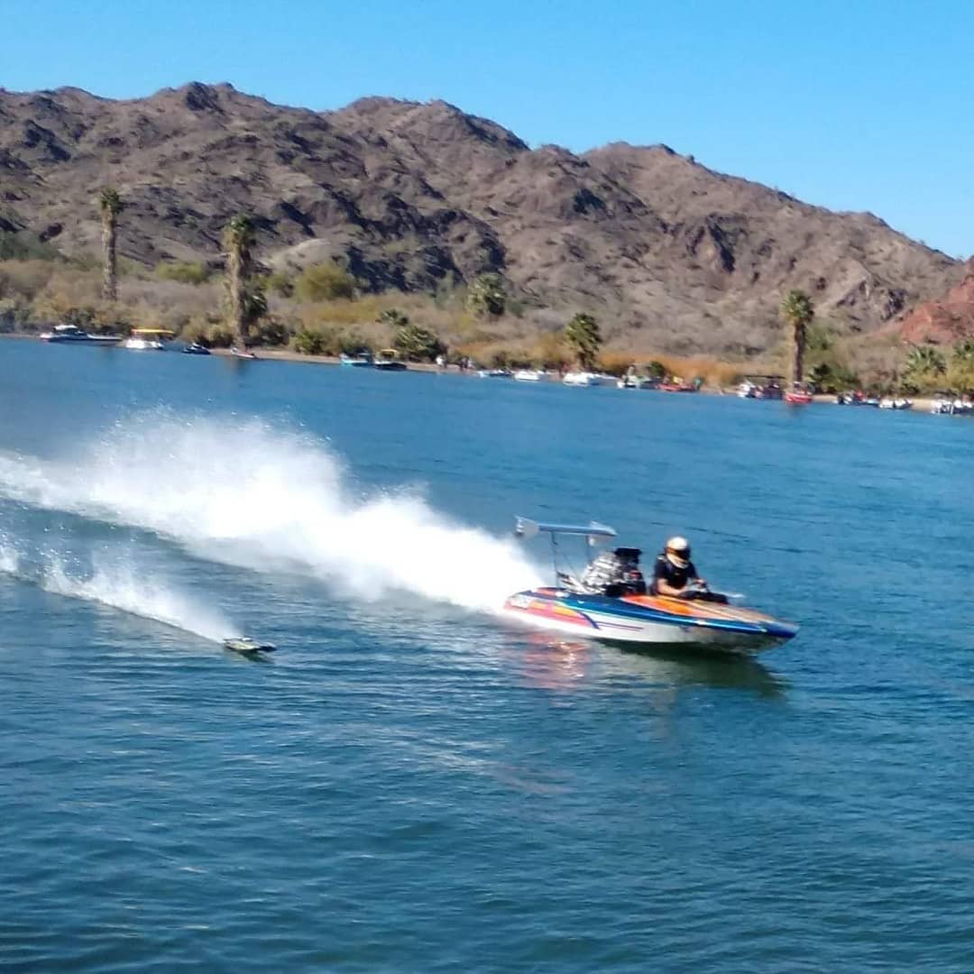 A full sized boat racing alongside an RC boat